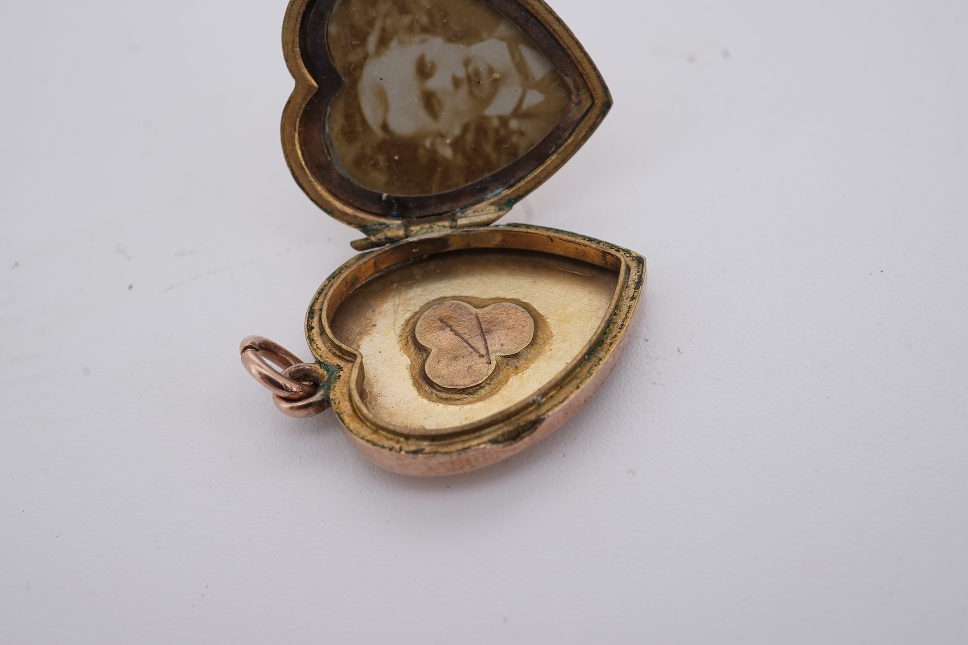 A Victorian yellow metal, amethyst and garnet cluster set brooch, 22mm, an early 20th century yellow metal and seed pearl set heart shaped locket, a yellow metal, garnet and zircon set three stone bar brooch and a tortoi